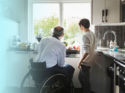 Older man in a wheel chair cooking with child