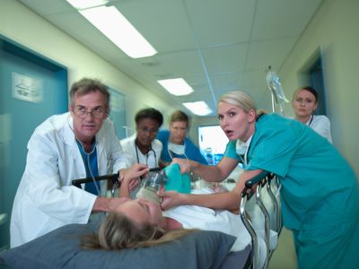 Nurses and doctors wheeling a patient on a gurney