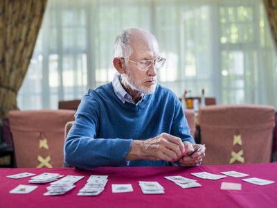 Senior man playing cards in nursing home