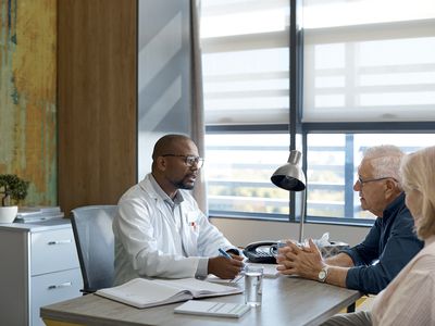 Healthcare worker having meeting with two people - stock photo