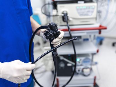 A healthcare provider holds an endoscope during a colonoscopy