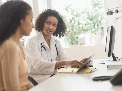 Doctor and patient using digital tablet in office