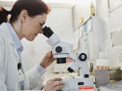 A doctor looks into a microscope.