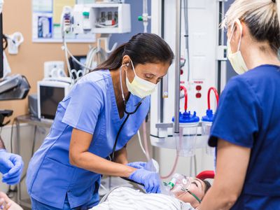 Healthcare providers work on person with signs of cardiac tamponade in emergency room