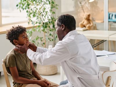 A healthcare provider examines a child for sore throat in a medical office