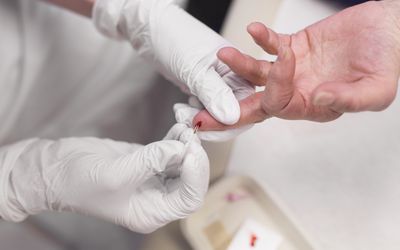 Doctor taking blood sample from a patient's finger