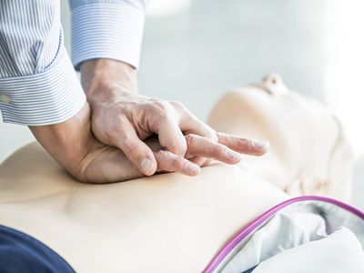 First-aider practising chest compressions