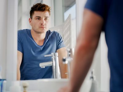 man looking in the bathroom mirror