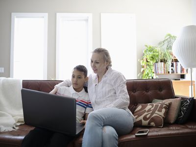 Mother and son using a laptop on a couch