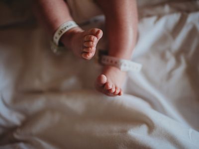 Newborn baby with medical ankle bracelet