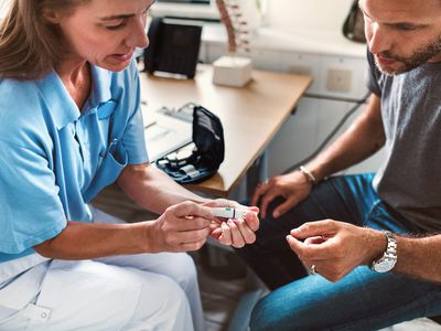 man learning how to use a glucometer