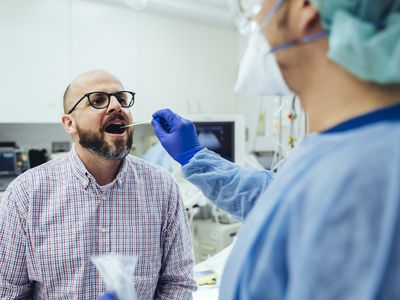 doctor taking swab of patient's mouth