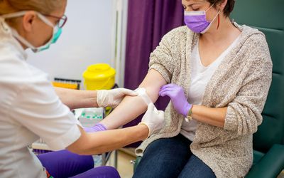 Applying adhesive bandage after taking sample for blood test