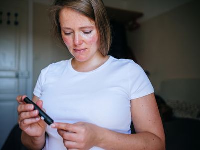 Woman doing blood sugar test at home