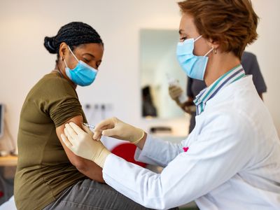 Older woman receiving a vaccine shot in the arm. 