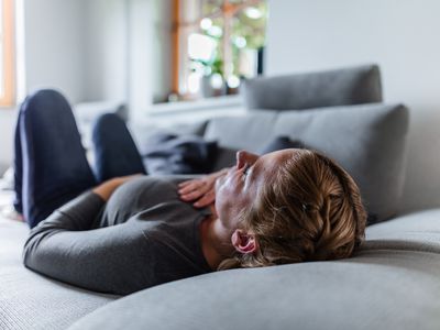 a sick woman lying on the couch