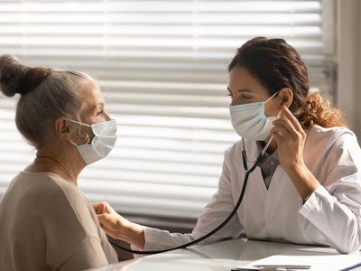 Female doctor listen to senior patient heart