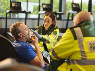 Man receiving oxygen through oxygen mask from paramedics