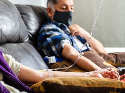 Midsection Of Man And Woman With Iv Drip On Hand In Hospital - stock photo