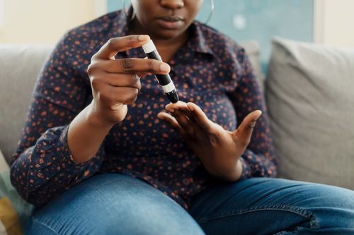 woman pricking her finger for blood sugar test