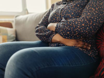 Woman Holding Belly, Feeling Discomfort - Stock Photo