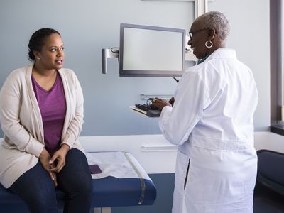 Smiling senior doctor talking to patient in hospital