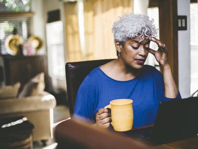 Older woman sicks at a table stressed 