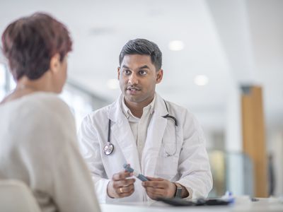 An adult patient talking to a younger provider in a white coat about insulin.