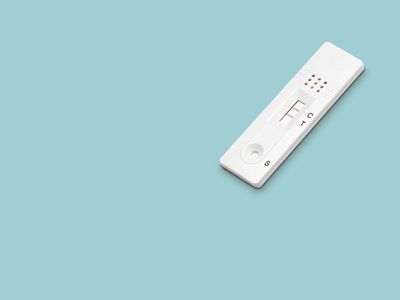 Positive rapid SARS COV 2 (Covid-19) antigen test on a blue background