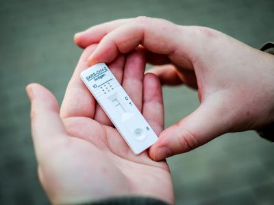 person holding positive covid antigen test