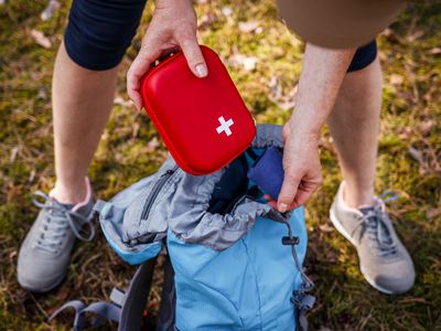 Woman taking a first aid kit out of a backpack during a hike