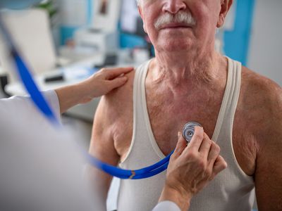 A close-up of unrecognizable senior man being checked by his doctor in doctor's office.