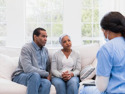 Couple sitting on couch talking to a healthcare provider