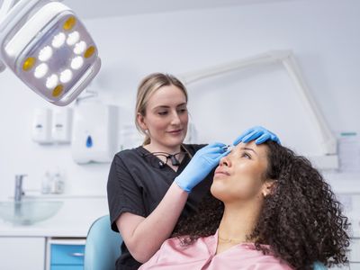 Licensed healthcare provider injecting Botox into a women in a sterile medical office