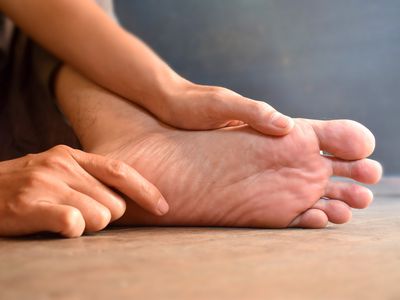 Close up image of the bottom of a person's foot and hands