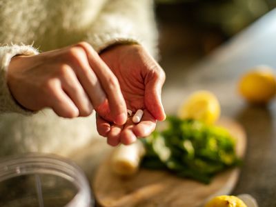 Taking a supplement in the kitchen close up