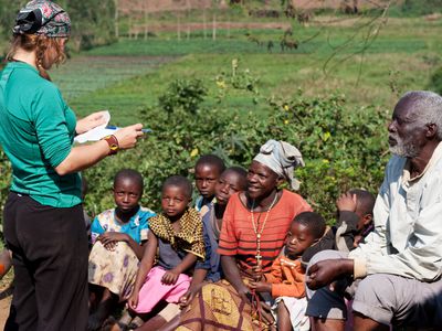 Humanitarian aid volunteer talking to villagers about malaria prevention