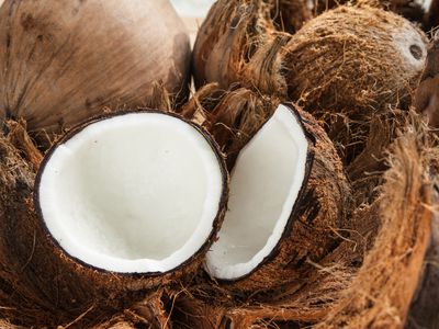 A halved coconut surrounded by brown shells