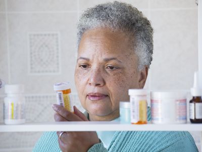 A woman examining her prescription bottles