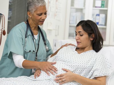 Doctor examining pregnant patient's belly