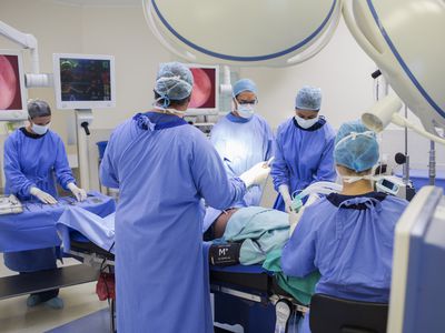 Team of doctors performing surgery in operating theater