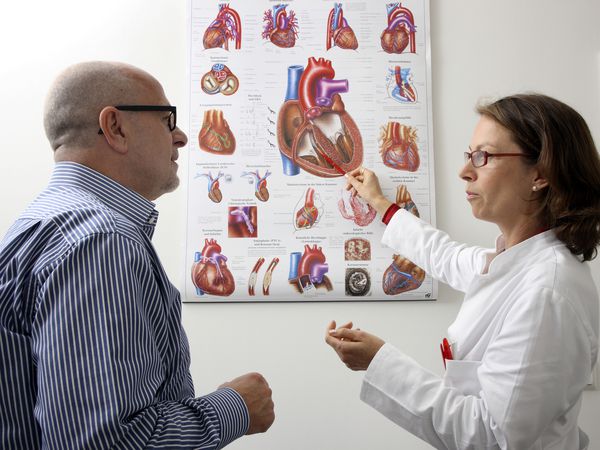 Medical practice, doctor explaining operation and possible diseases of the human heart to a patient