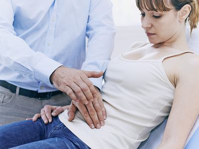 Doctor doing abdominal check on a woman