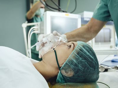 Patient with a respiratory mask on operating table.