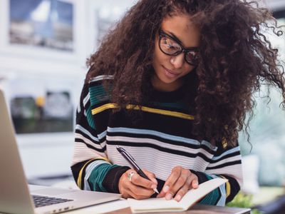 Woman at a computer taking notes