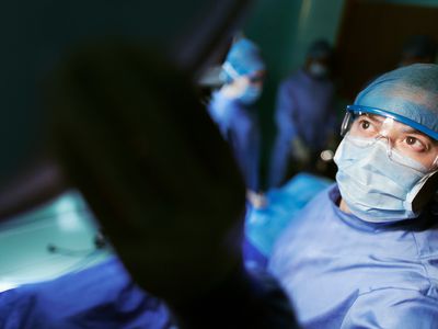 A doctor adjusting light in operating room