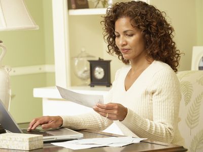 Woman sitting in front of laptop, paying bills online