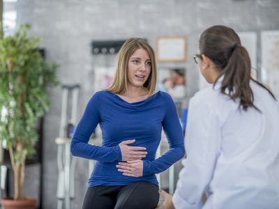 Woman complaining of A Stomachache to her doctor