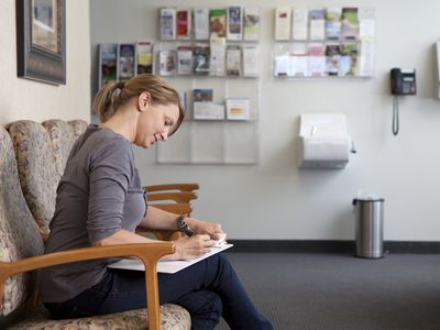 woman filling out forms at doctor's office