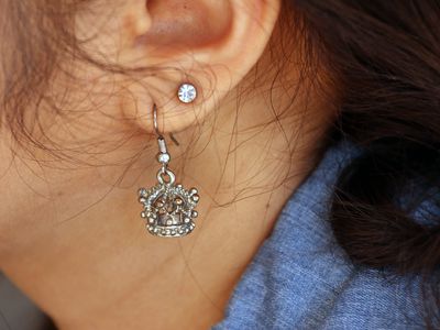 Close up of two earrings in a woman's ear